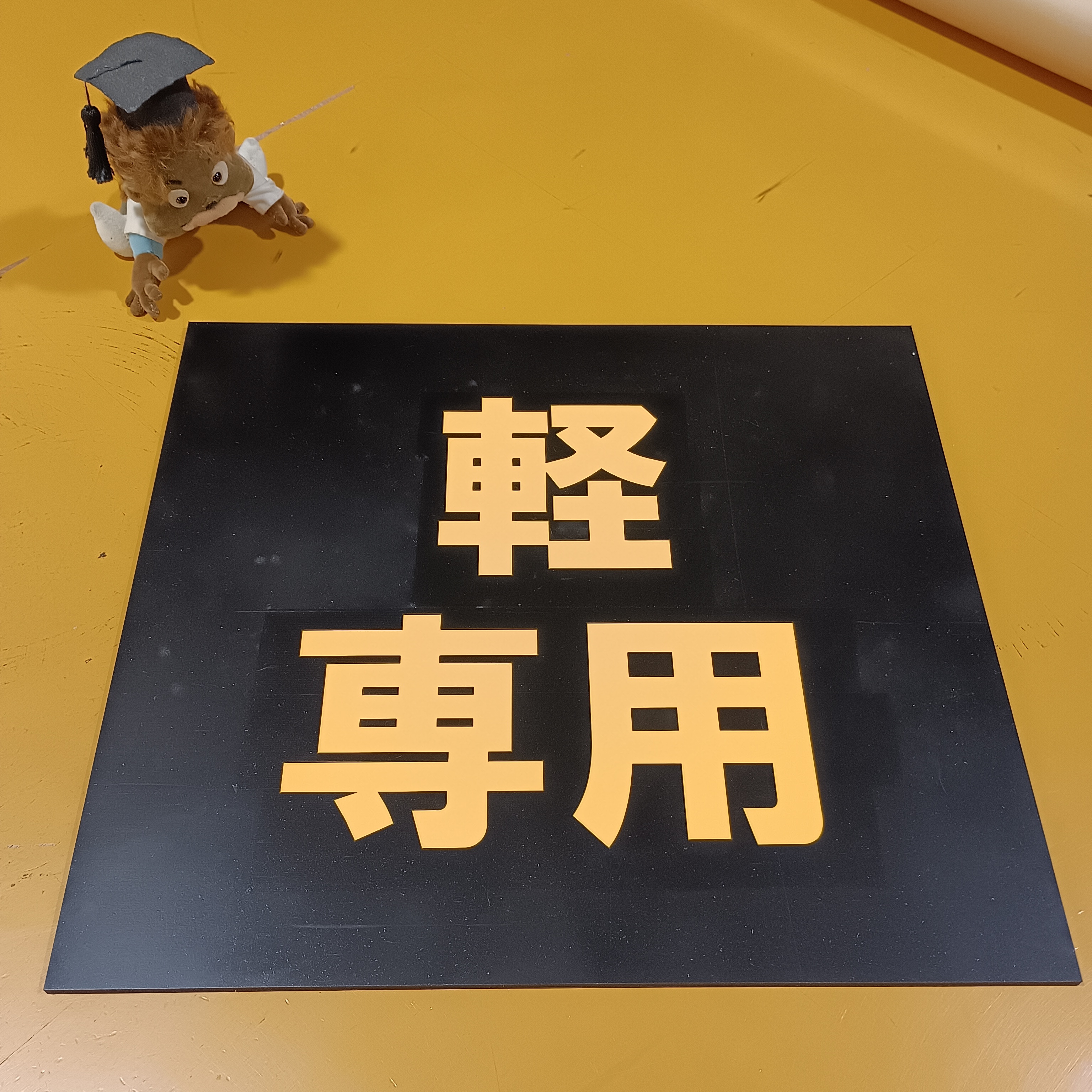 黒地に黄色の軽専用と書かれた駐車場用ゴムシート